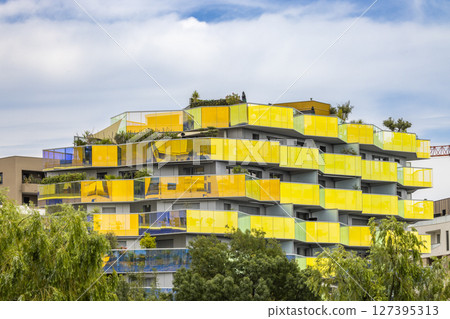 Colorful building with yellow and green balconies reflecting the sky in Montpellier, France 127395313