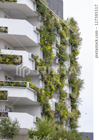 Green wall covering facade of modern building in Montpellier, France 127395317
