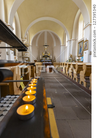 Burning votive candles illuminating church interior in Harrachov, Czechia 127395340
