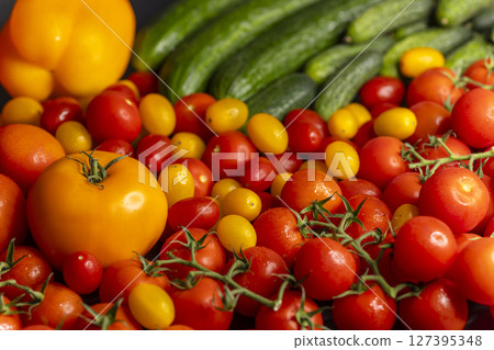Fresh organic vegetables creating a colorful composition with tomatoes, cucumbers and bell pepper 127395348