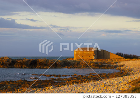 German bunker overlooking the english channel at sunset in Normandy, France German bunker overlooking the english channel at sunset in Normandy, France 127395355