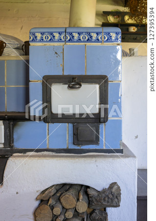 Old vintage blue tiled stove with firewood in Kourim, Czechia Old vintage blue tiled stove with firewood in Kourim, Czechia 127395394