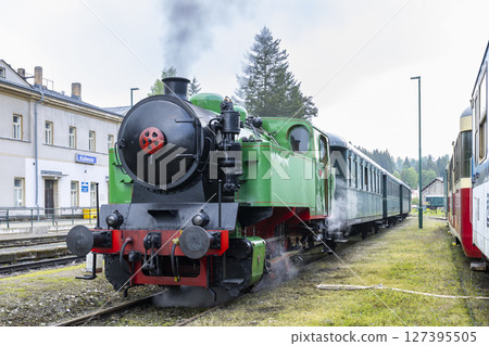 Vintage steam train departing from Korenov station in Czechia, Liberecky kraj 127395505