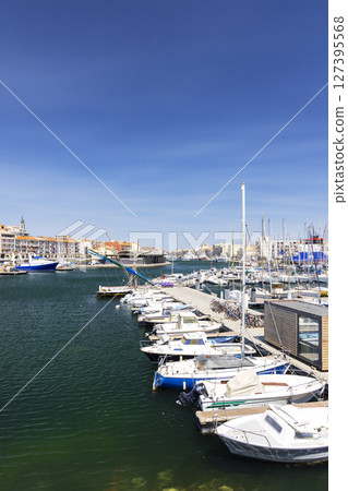 Boats mooring at Mole Saint Louis in Sete, France, under a blue sky 127395568