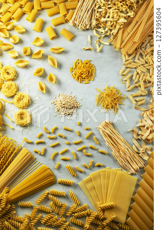Various types of italian pasta forming a frame on a gray background Various types of italian pasta forming a frame on a gray background 127395604