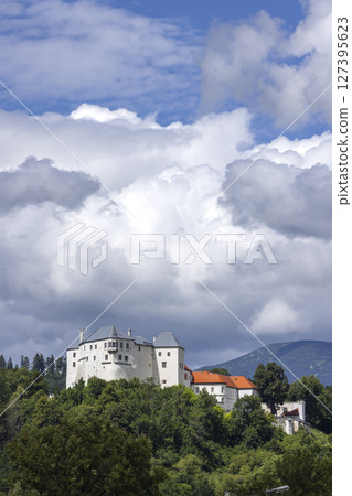 Slovenska Lupca Castle rising above the trees in Slovakia under cloudy sky 127395623