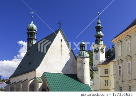 Church of the Assumption of the Virgin Mary with green roof and clock tower in Banska Stiavnica, Slovakia 127395625