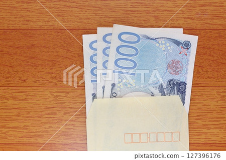 棕色信封裡的 1000 日元鈔票 棕色信封裡的 1000 日元鈔票 127396176