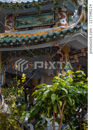 Ornate pavilion roof with dragon carvings in Marble Mountains, Traditional ceramic-roofed pavilion surrounded by greenery in Marble Mountains Vietnam 127396214