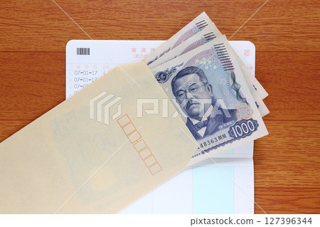 1,000 yen bills and bankbook in a brown envelope 127396344