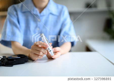 Close up of female hands preparing for blood glucose test, healthcare and wellness concept 127396891