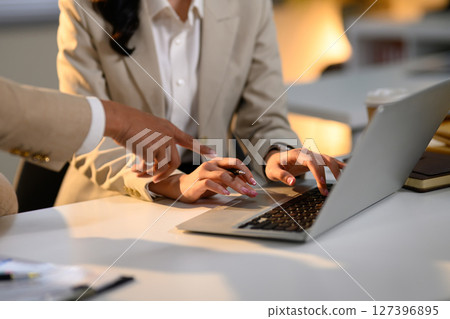 Close up of business teamwork sharing input and reviewing data during a business task 127396895