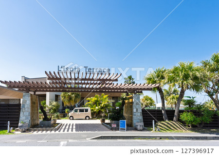 The store, building and signboard of "Amakusa Pearl Garden & Underwater Aquarium Sea Donuts" stand out against the blue sky. 127396917