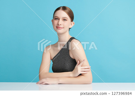 A beautiful young woman with clean, fresh skin against a blue background. Skincare, facial treatment, cosmetology, beauty, and spa. An elegant portrait of an woman. A beautiful young woman with clean, fresh skin against a blue background. Skincare, facial treatment, cosmetology, beauty, and spa. An elegant portrait of an woman. 127396984