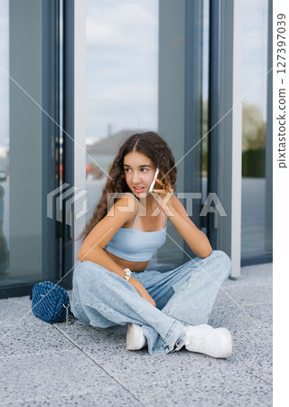 Stylish Teen Girl Talking On Smartphone 127397039