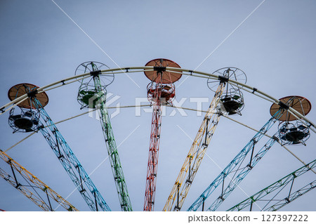Colorful Ferris Wheel Against Clear Blue Sky at Amusement Park 127397222