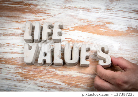 Life Values. Concrete alphabet letters on a light painted wood texture background Life Values. Concrete alphabet letters on a light painted wood texture background 127397223