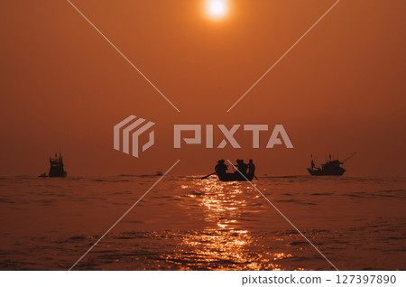 Silhouettes of Vietnamese fishermen on baskets boats and ships at sea in a fishing village in the morning at sunrise in Vietnam Silhouettes of Vietnamese fishermen on baskets boats and ships at sea in a fishing village in the morning at sunrise in Vietnam 127397890