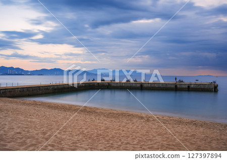 Pier in the sea at the sandy beach at dawn in the morning in Nha Trang in Vietnam. Long exposure 127397894