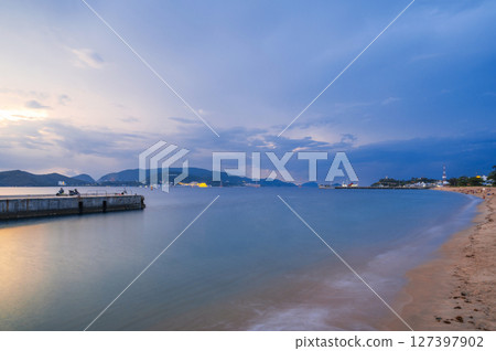 View of Vinpearl Island in Nha Trang in Vietnam in the sea at sunrise in the cloudy morning. Long exposure landscape View of Vinpearl Island in Nha Trang in Vietnam in the sea at sunrise in the cloudy morning. Long exposure landscape 127397902