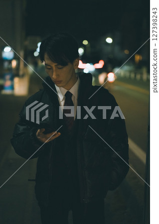 Night road, young man, smartphone 127398243