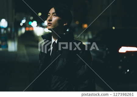 一個人在晚上走在城市 127398261