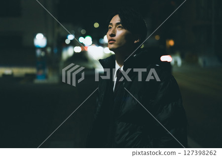 Man walking in the city at night 127398262