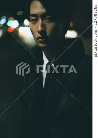 Man walking in the city at night 127398269
