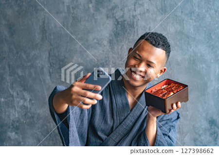 一名黑人男子在日本餐廳拍攝鰻魚飯 127398662