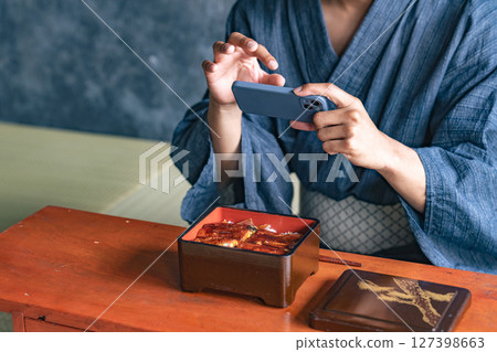 一名黑人男子在日本餐廳拍攝鰻魚飯 127398663