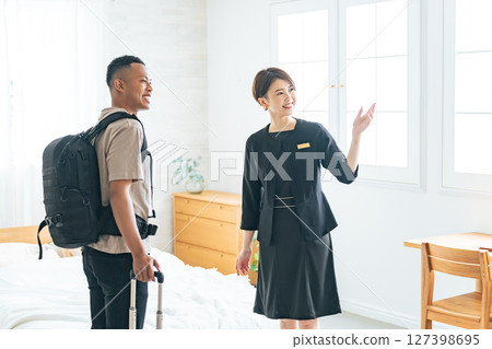 Female hotel staff showing a black male tourist to his room 127398695