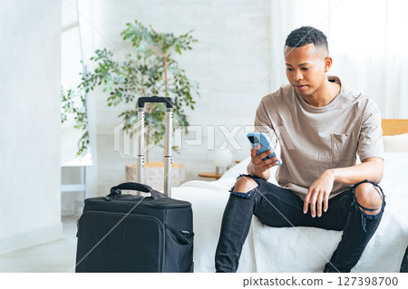 黑人男性旅行者在飯店房間看智慧型手機 127398700