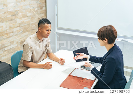 一名黑人男子和一名日本女工作人員正在接受採訪 一名黑人男子和一名日本女工作人員正在接受採訪 127398703