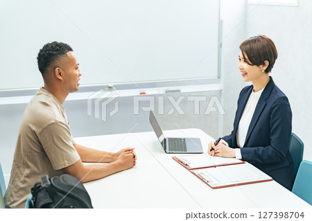 一名黑人男子和一名日本女工作人員正在接受採訪 127398704