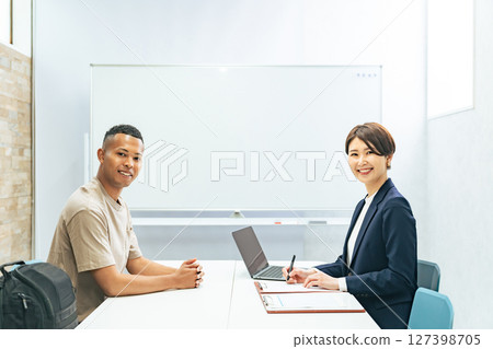 一名黑人男子和一名日本女工作人員正在接受採訪 一名黑人男子和一名日本女工作人員正在接受採訪 127398705