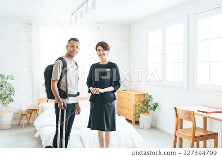 Female hotel staff showing a black male tourist to his room 127398709