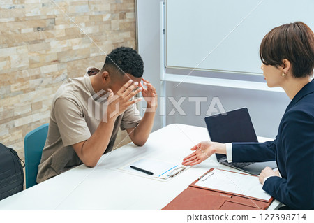 一名日本女工作人員正在採訪一名陷入困境的黑人男子 127398714