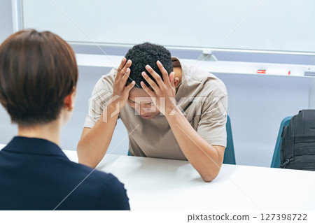A Japanese female staff member interviewing a troubled black man 127398722
