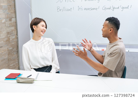 一名黑人男子和一名日本女子在教室裡交談 127398724