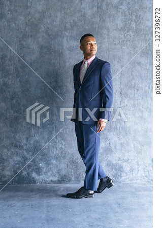 Black male businessman standing in a dark room 127398772