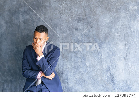 一位黑人男性商人在黑暗的房間裡憂心忡忡 一位黑人男性商人在黑暗的房間裡憂心忡忡 127398774