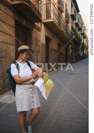 Curious Female Tourist Exploring Old Town Streets Using a Map 127399408