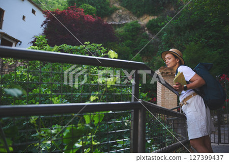Woman Tourist Exploring Picturesque Small Town Streets with a Map 127399437