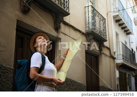 Woman Tourist Exploring a Scenic Medieval Street with a Map 127399458