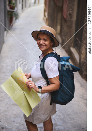 Woman Exploring Medieval City Streets With a Map and Backpack Woman Exploring Medieval City Streets With a Map and Backpack 127399464