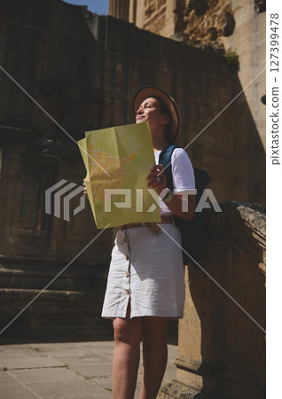 Woman Exploring a Historic City with a Map on a Sunny Day Woman Exploring a Historic City with a Map on a Sunny Day 127399478