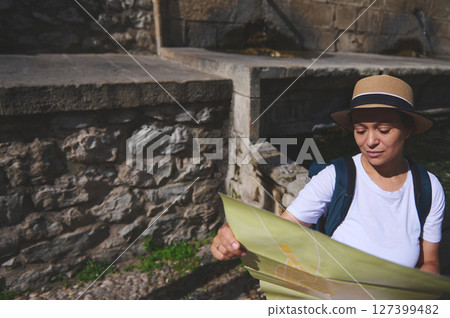 Tourist Exploring a Historic Stone Landmark While Studying a Map Outdoors 127399482