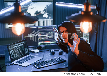 Got caught. With hands up. Male professional hacker is sitting by computer, conception of virus Got caught. With hands up. Male professional hacker is sitting by computer, conception of virus 127399619