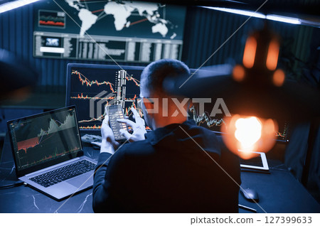 Financial Analyst Working on a Computer with Multi-Monitor Workstation with Real-Time Stocks, Commodities and Exchange Market Charts. Financial Analyst Working on a Computer with Multi-Monitor Workstation with Real-Time Stocks, Commodities and Exchange Market Charts. 127399633