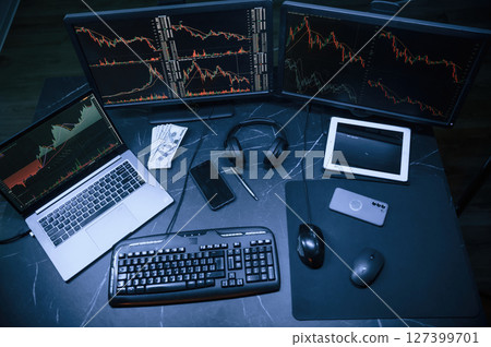 Financial Analyst Working on a Computer with Multi-Monitor Workstation with Real-Time Stocks, Commodities and Exchange Market Charts. 127399701